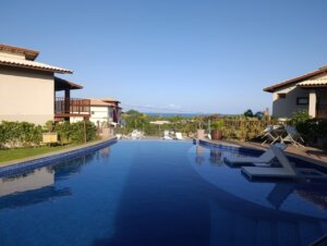 Piscina com cascata e prainha no condomínio Oahu Alto de Imbassaí